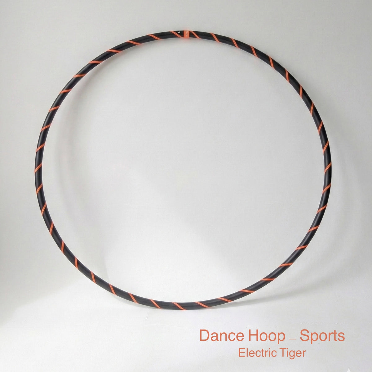 Dance hula hoop – Electric Tiger Sports Edition. Professional black tubing featuring a UV-sensitive fluoro orange spiral tape design.