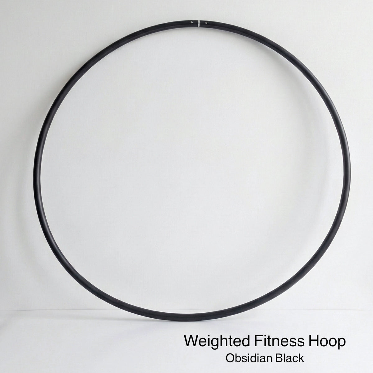 Weighted fitness hula hoop for adults in Obsidian Black, featuring untaped natural grip tubing for professional core workouts.
