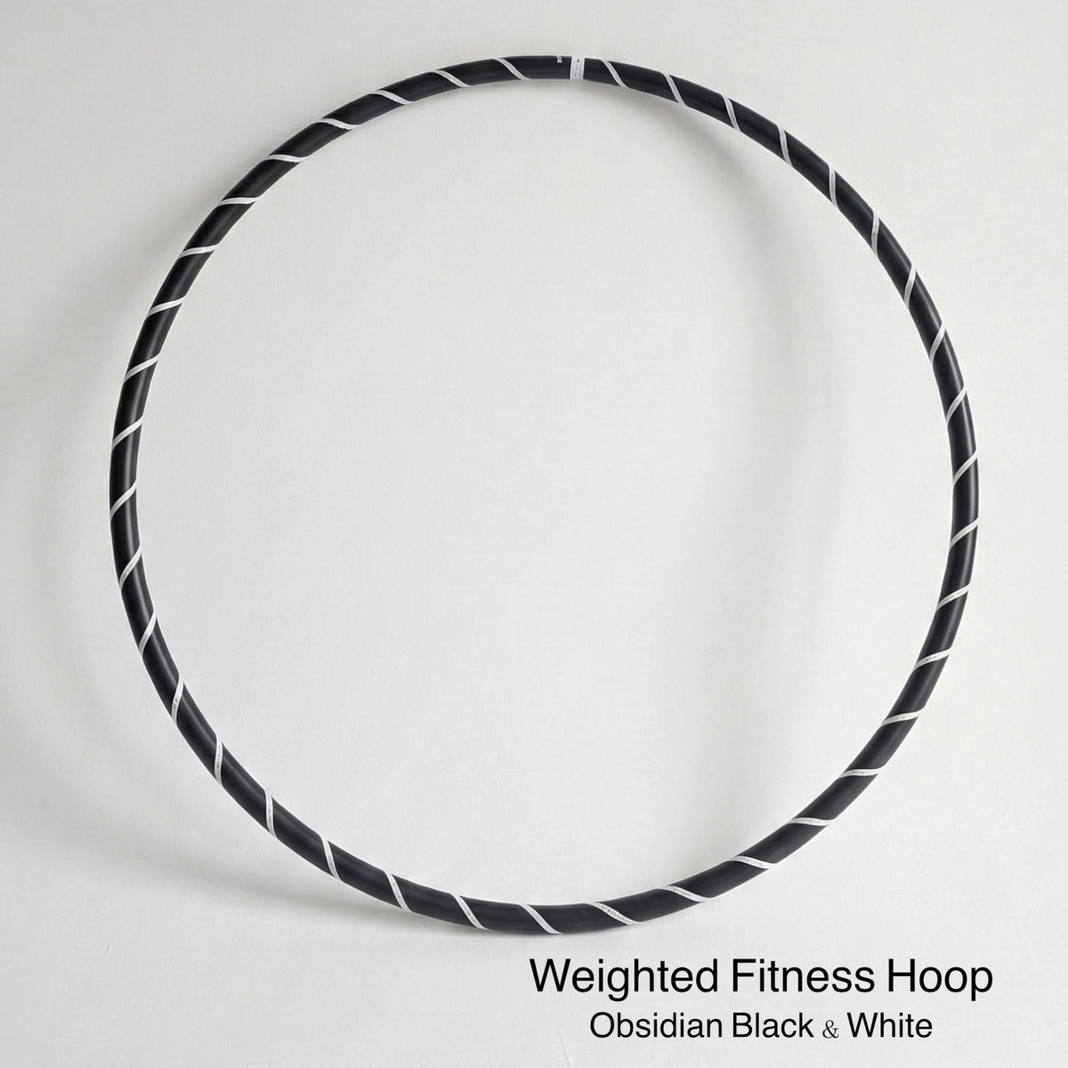 Weighted fitness hula hoop for adults in Obsidian Black sports model, featuring professional black tubing with a sleek white spiral tape design. 